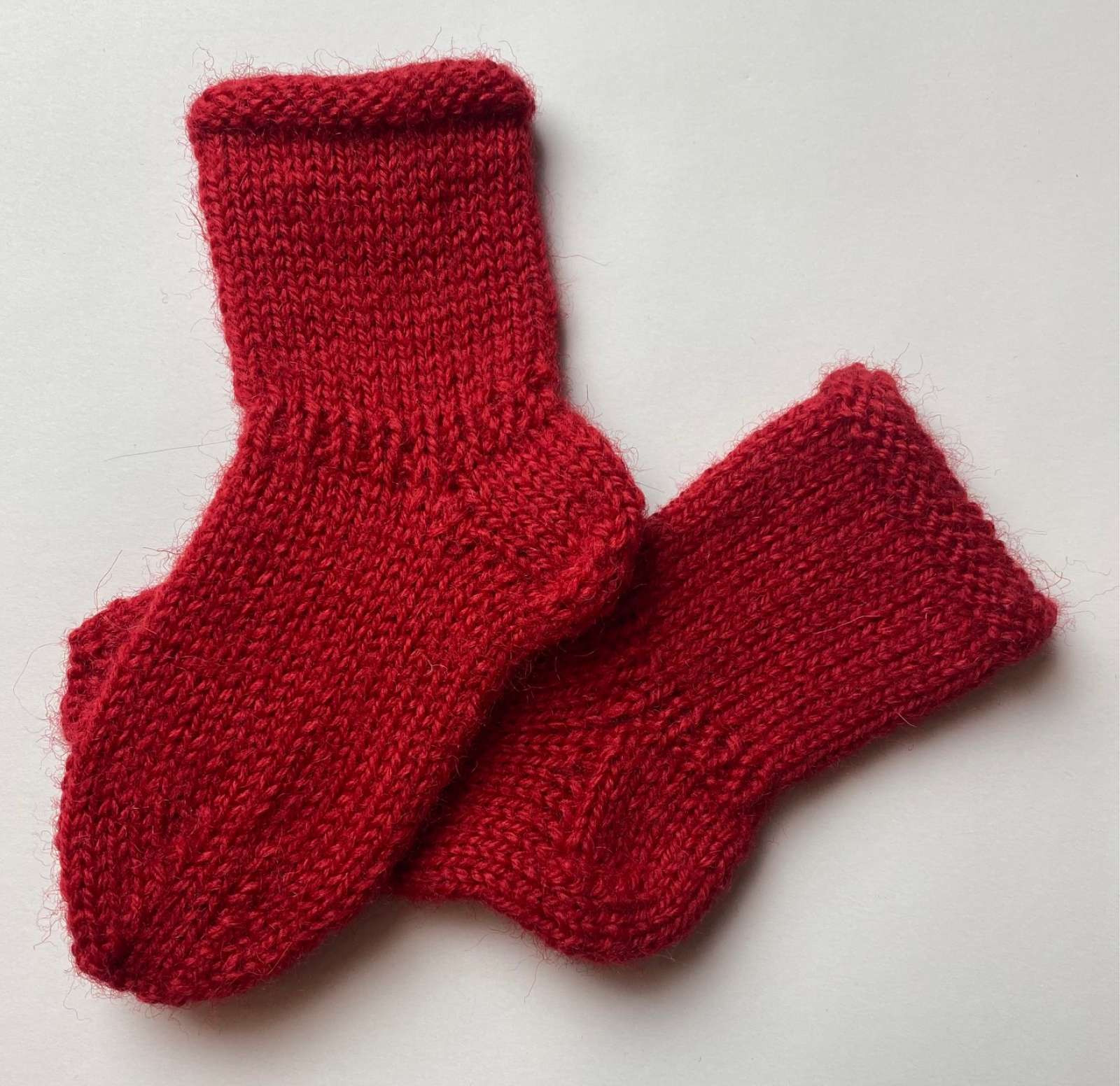 „Pirmieji prisilietimai“ – rankų darbo vilnonės kūdikio kojinaitės (10 cm)