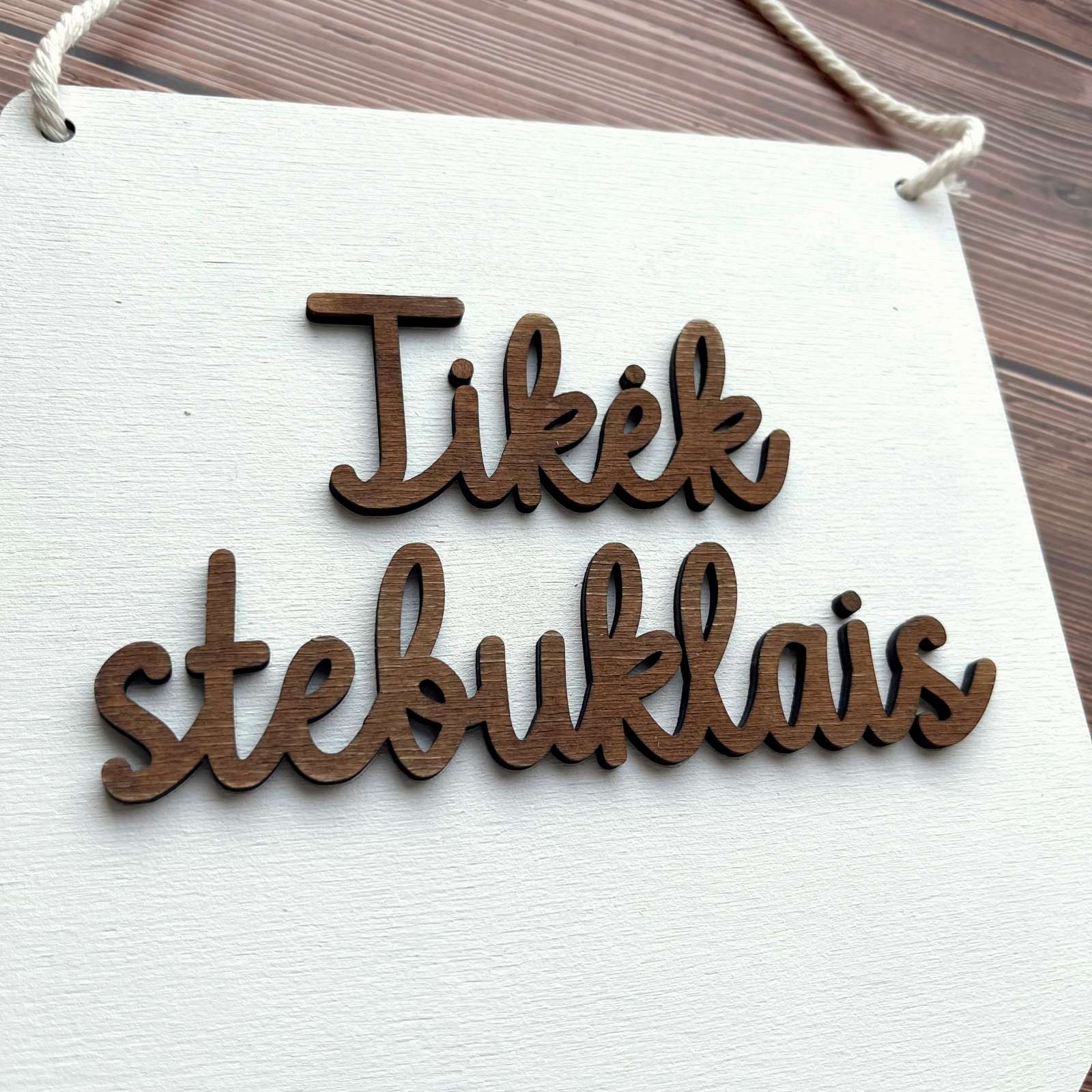 Medinė vėliavėlė su motyvaciniu užrašu.