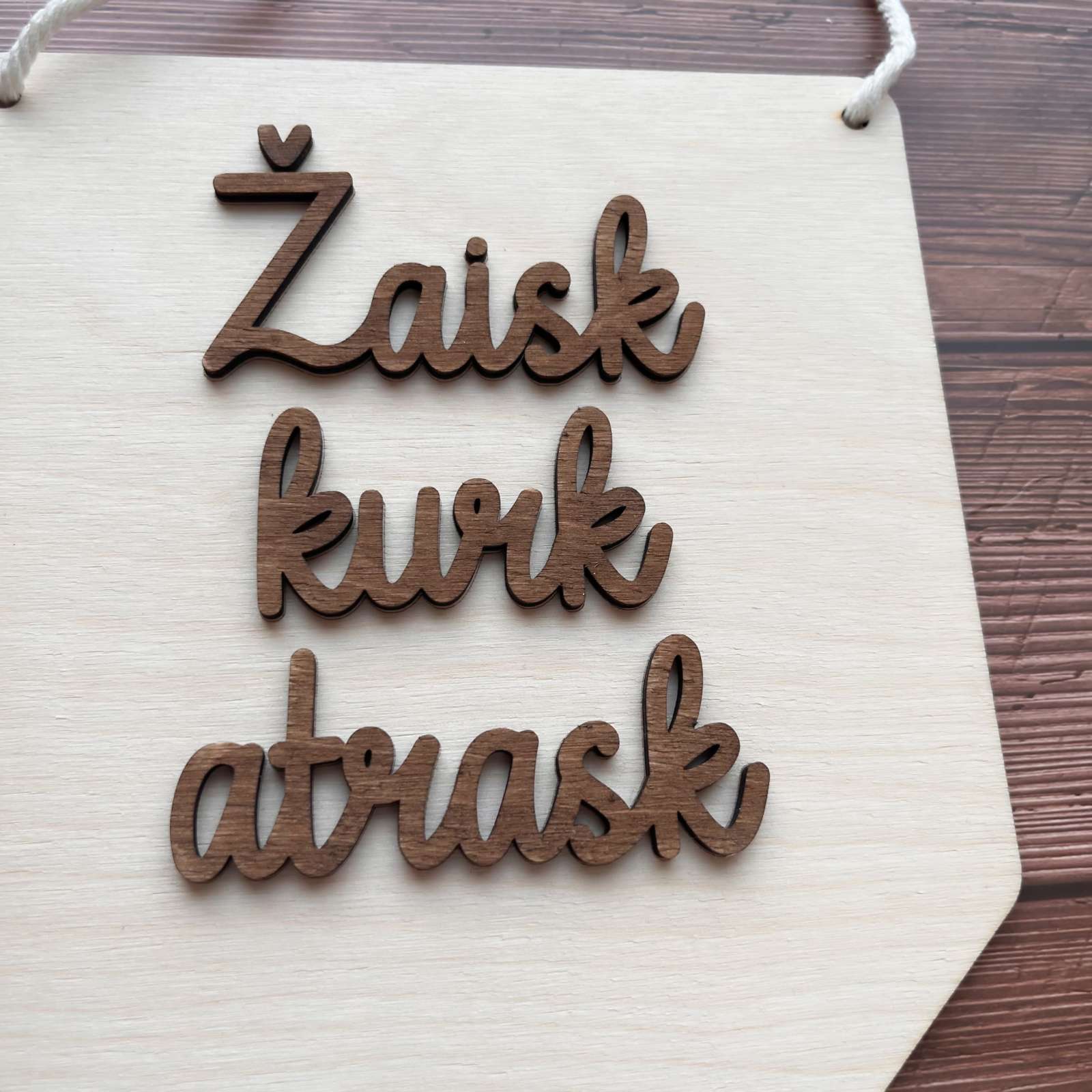 Medinė vėliavėlė su motyvaciniu užrašu.